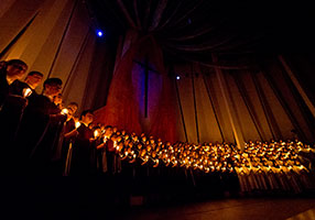 Choir holding candles in the dark. Links to Gifts by Estate Note